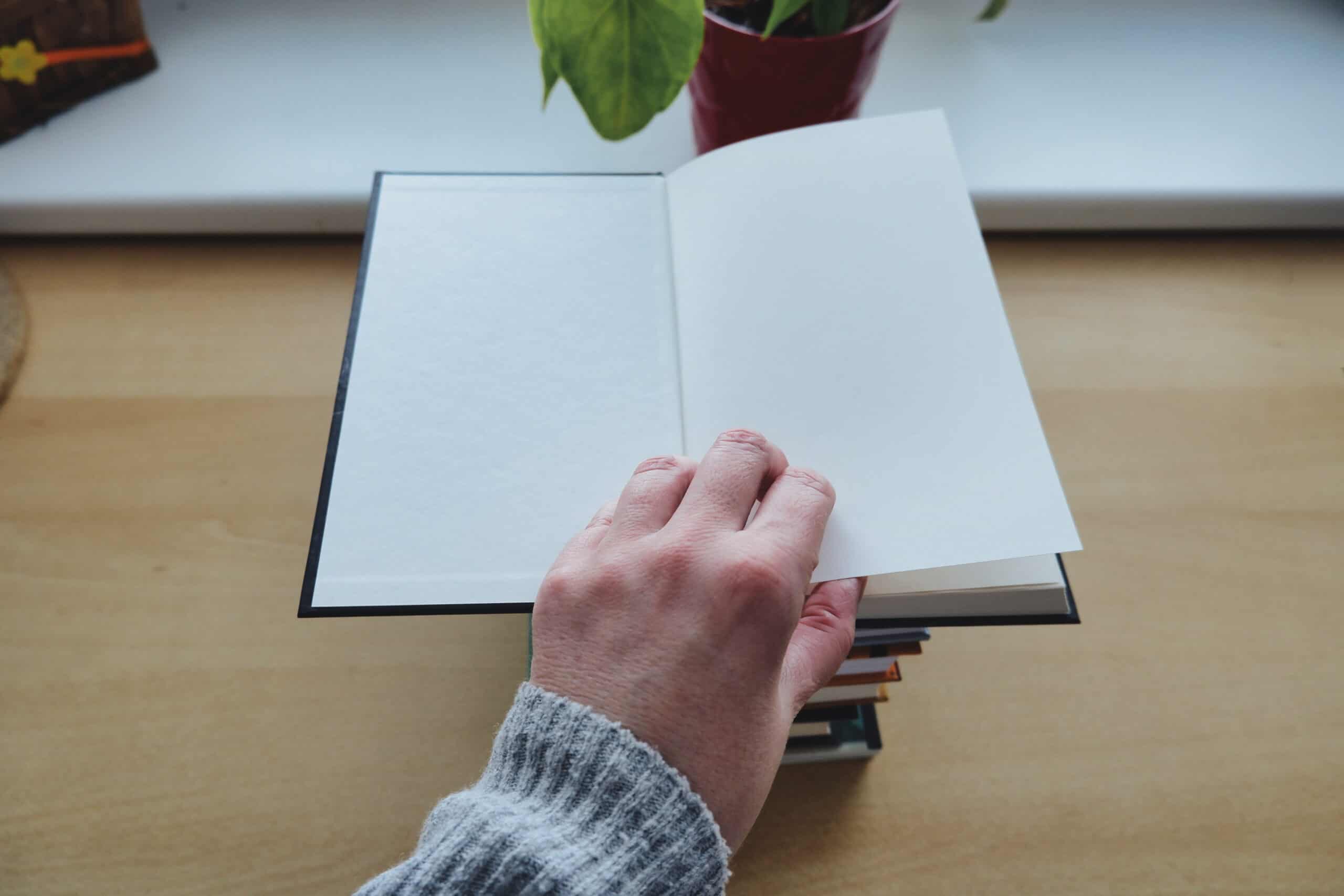 Person in gray sweater holding white paper about me